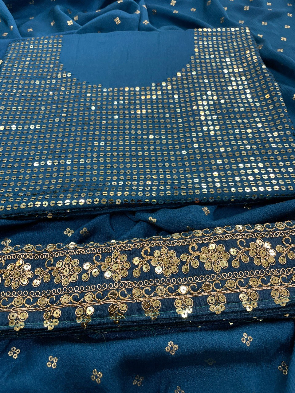 Peacock blue silk saree featuring stunning gold and silver zari and sequin embellishments.