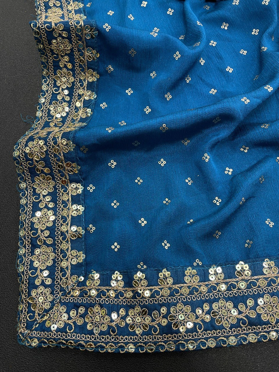 Peacock blue silk saree featuring stunning gold and silver zari and sequin embellishments.