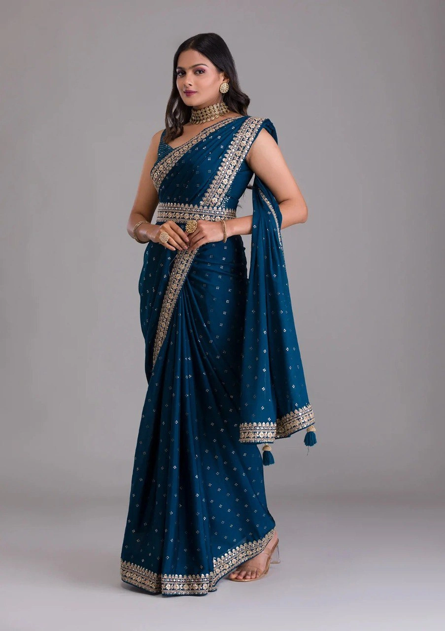 Peacock blue silk saree featuring stunning gold and silver zari and sequin embellishments.