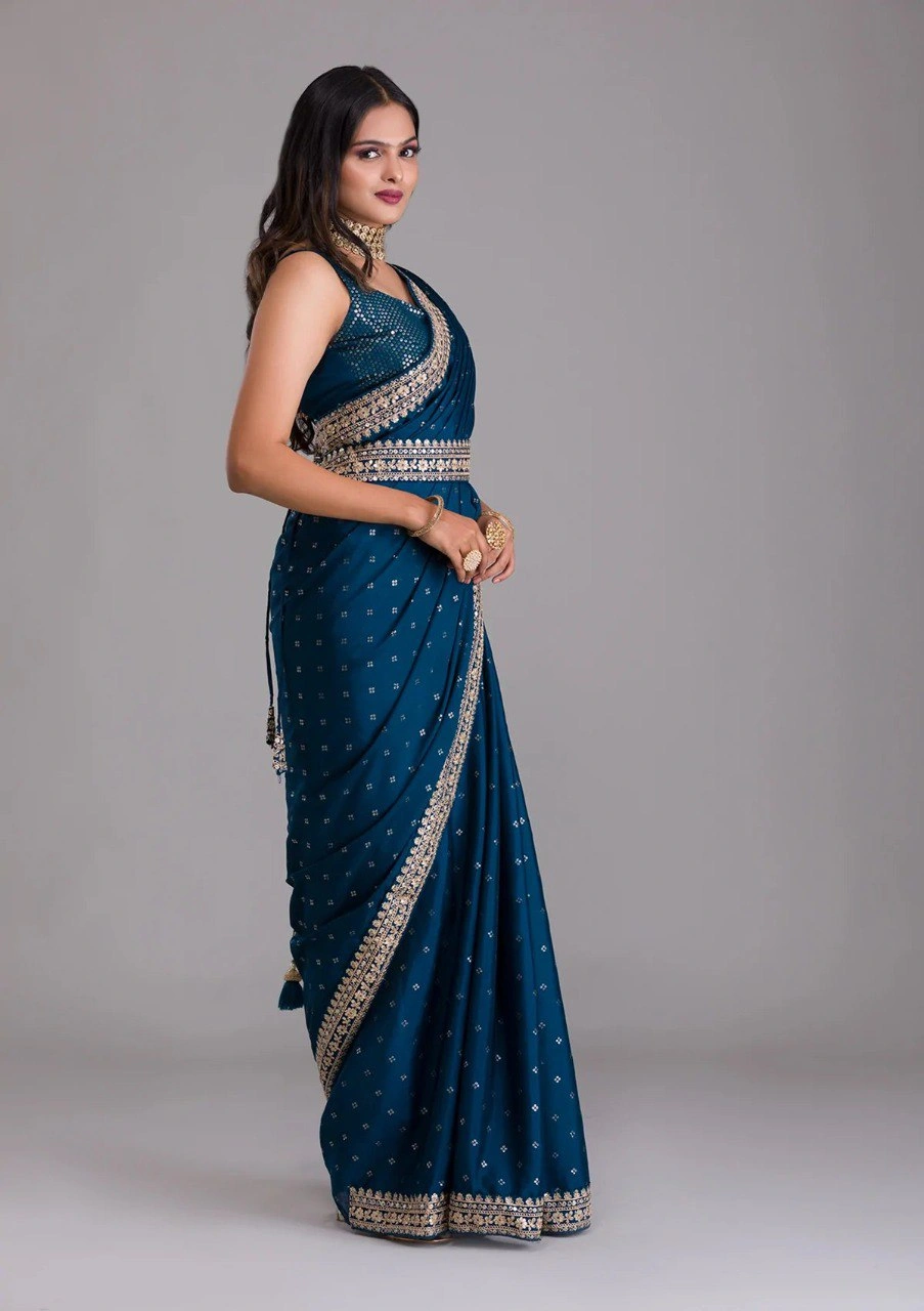 Peacock blue silk saree featuring stunning gold and silver zari and sequin embellishments.