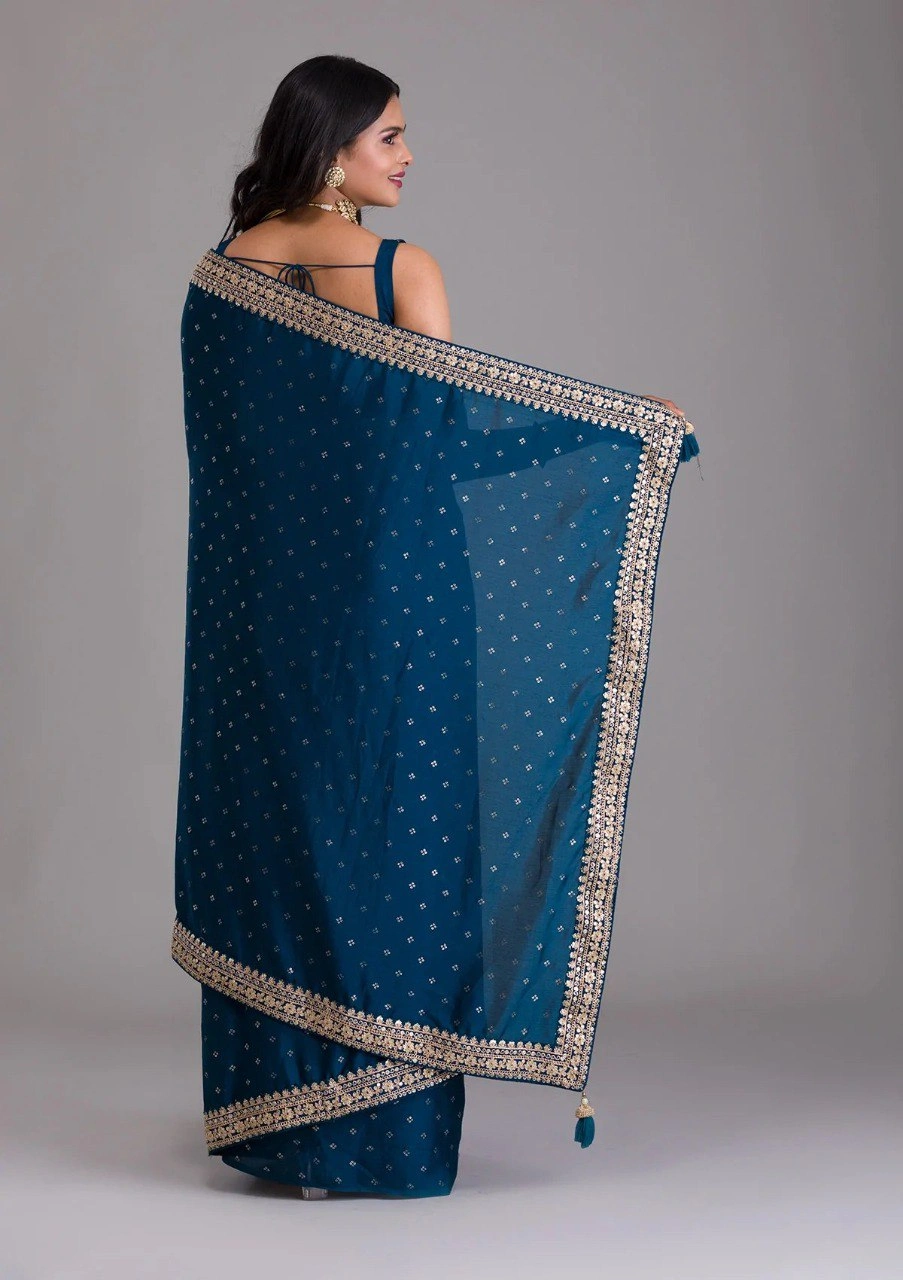 Peacock blue silk saree featuring stunning gold and silver zari and sequin embellishments.