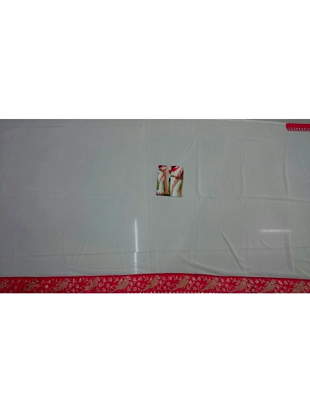 A stunning woman in a cream embroidered georgette saree, highlighted with red and white patterns.