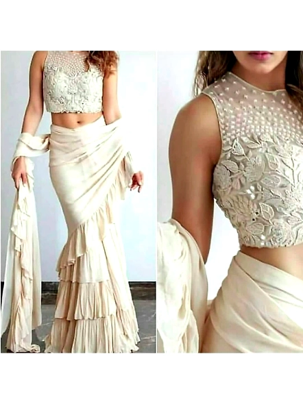 A beautiful woman wearing a white ruffle georgette saree with a matching blouse, elegantly posed.