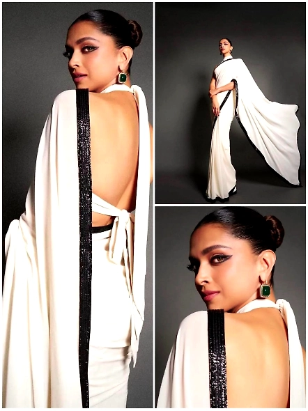 A woman wearing a white sari with a black border, featuring sequence work and lace detailing, styled