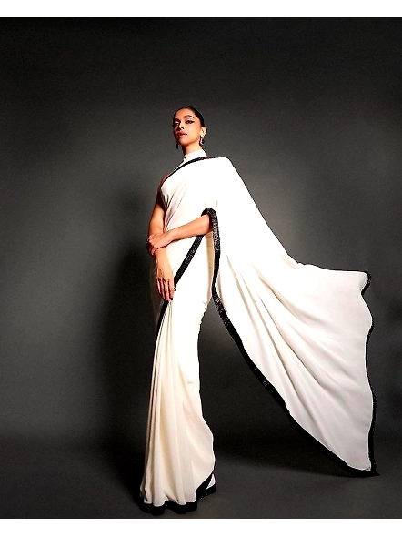 A woman in a white sari with a black lace border, showcasing sequence work, inspired by Deepika Padu