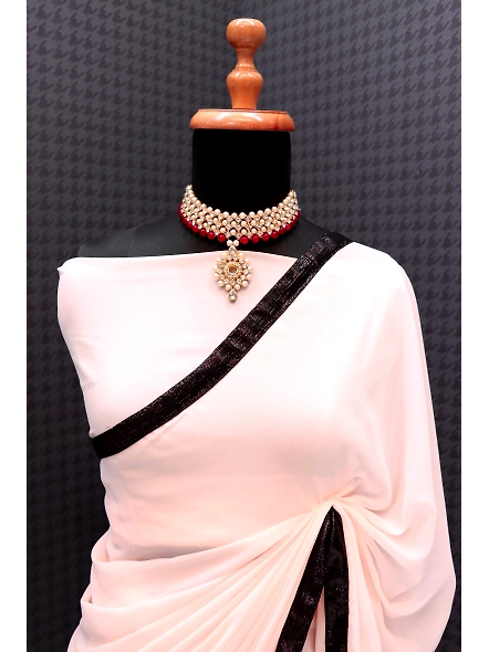 A woman in a white sari with a black border, embellished with sequence work and lace, designed by De