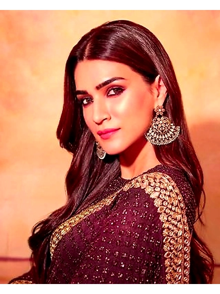 A woman in a maroon Kriti Sanon Brown Georgette saree, embodying grace and traditional Indian fashio