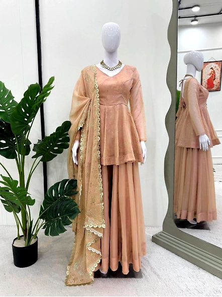 A woman in a beige lehenga paired with a gold necklace, modeling the stylish Tabby Organza Kurta Set