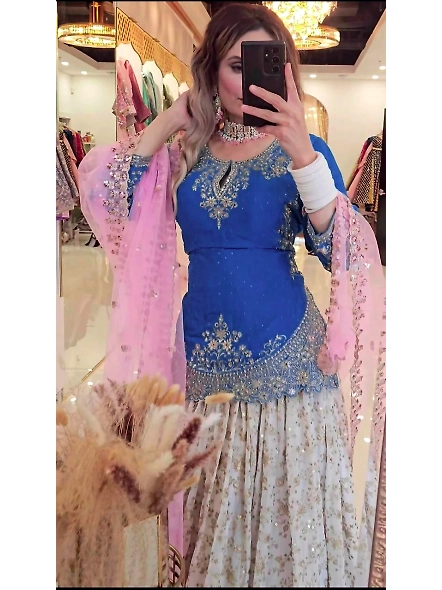 A woman in a stunning cyan and pink lehenga, made of Chinon silk, showcasing elegance for festive ce