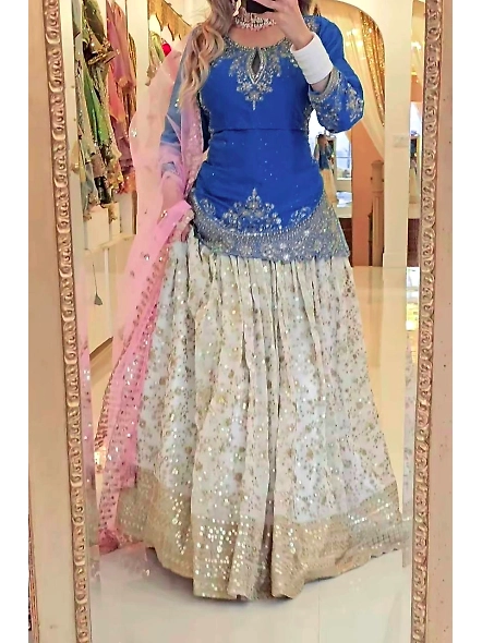 A woman adorned in a blue and pink Chinon silk lehenga, designed for special celebrations and festiv