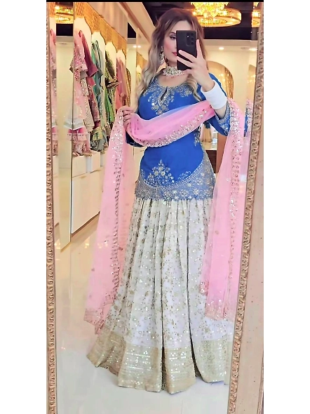 A woman wearing a cyan and pink lehenga made of Chinon silk, perfect for festive celebrations.