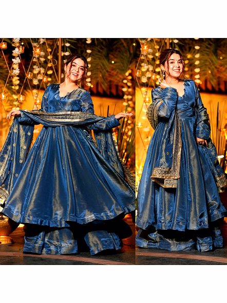 A beautiful woman wearing a blue Vichitra silk gown with sequin work and a gold dupatta, exuding ele