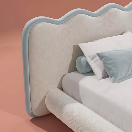 Close-up of cream upholstered bed headboard – textured fabric finish and wave design
