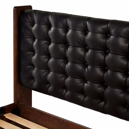 Close-up of tufted black leatherette headboard on handcrafted Master Teakwood bed.