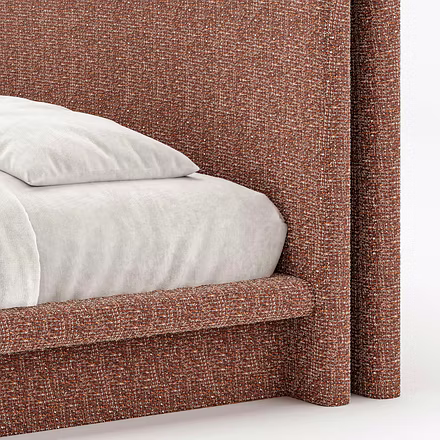 Close-up detail of textured rust upholstery on Drift upholstered bed showing rounded base and headbo