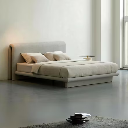 Studio shot of Drift upholstered bed in neutral-beige fabric highlighting double-fold rounded headbo