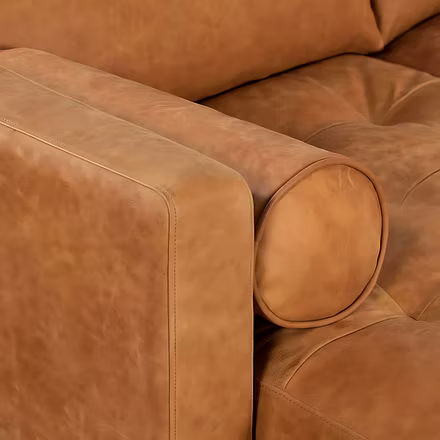 Close-up of tan Alba L Shape Sofa armrest with leather bolster pillow