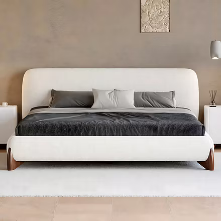 Front view of a white Ashlie upholstered bed with gray linens against a textured gray wall with a de