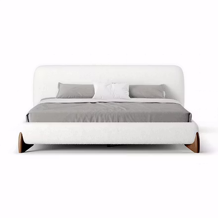 A white Ashlie upholstered bed with curved headboard and walnut wood legs on a plain background, ava