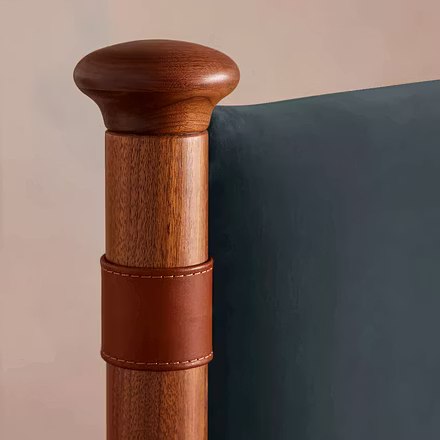 Close-up of teakwood pillar with leather detailing on Victorian upholstered bed, available in king a