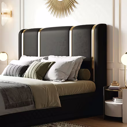 Side angle view of Tune black upholstered bed with gold detailing, elegant bedroom furniture from Wo