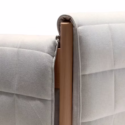 (Backrest Close-up): Close-up of sofa backrest with neatly wrapped ivory upholstery over teakwood fr