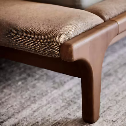 Detailed view of teak frame joint and padded footboard bench upholstery illustrating craftsmanship —