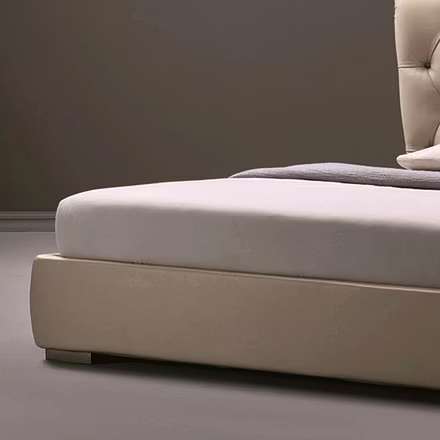 Front bedroom shot of Archies upholstered bed with textured linen and accent pillows beside a wooden