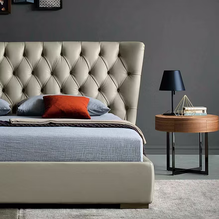 Angled lifestyle photo of Archies upholstered bed with city night view and button-tufted headboard d
