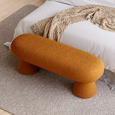 Top-down angle of Terra bench showing bouclé texture and tapered cone legs next to neutral bed and k