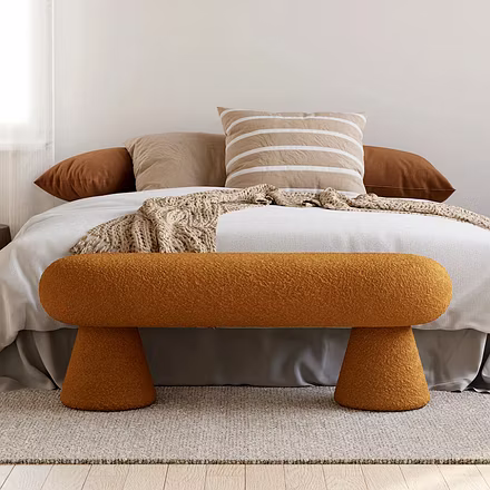 Centered bedroom scene with Terra bench in terracotta at bed footboard, showcasing low-profile sculp