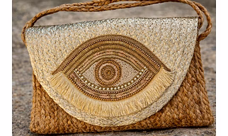 Artisanal Woven Jute Sling Bag with Metallic Golden Yellow Color Flap, Intricate Evil Eye Beadwork, and Bohemian Fringe Detailing for International Markets