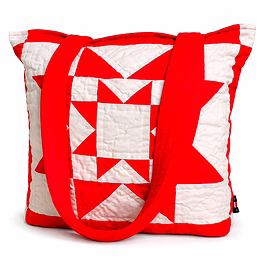 quilted patchwork tote bag with red and white geometric block design and wide fabric shoulder straps