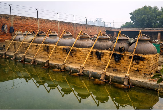 Copper distillation unit with sandalwood and lab vials symbolizing pure, certified sandalwood oil pr