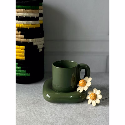 dark green ceramic cup with attached saucer