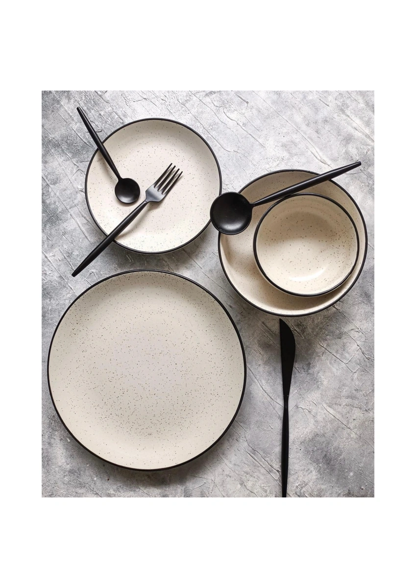 Three speckled plates with black cutlery on a gray textured surface.