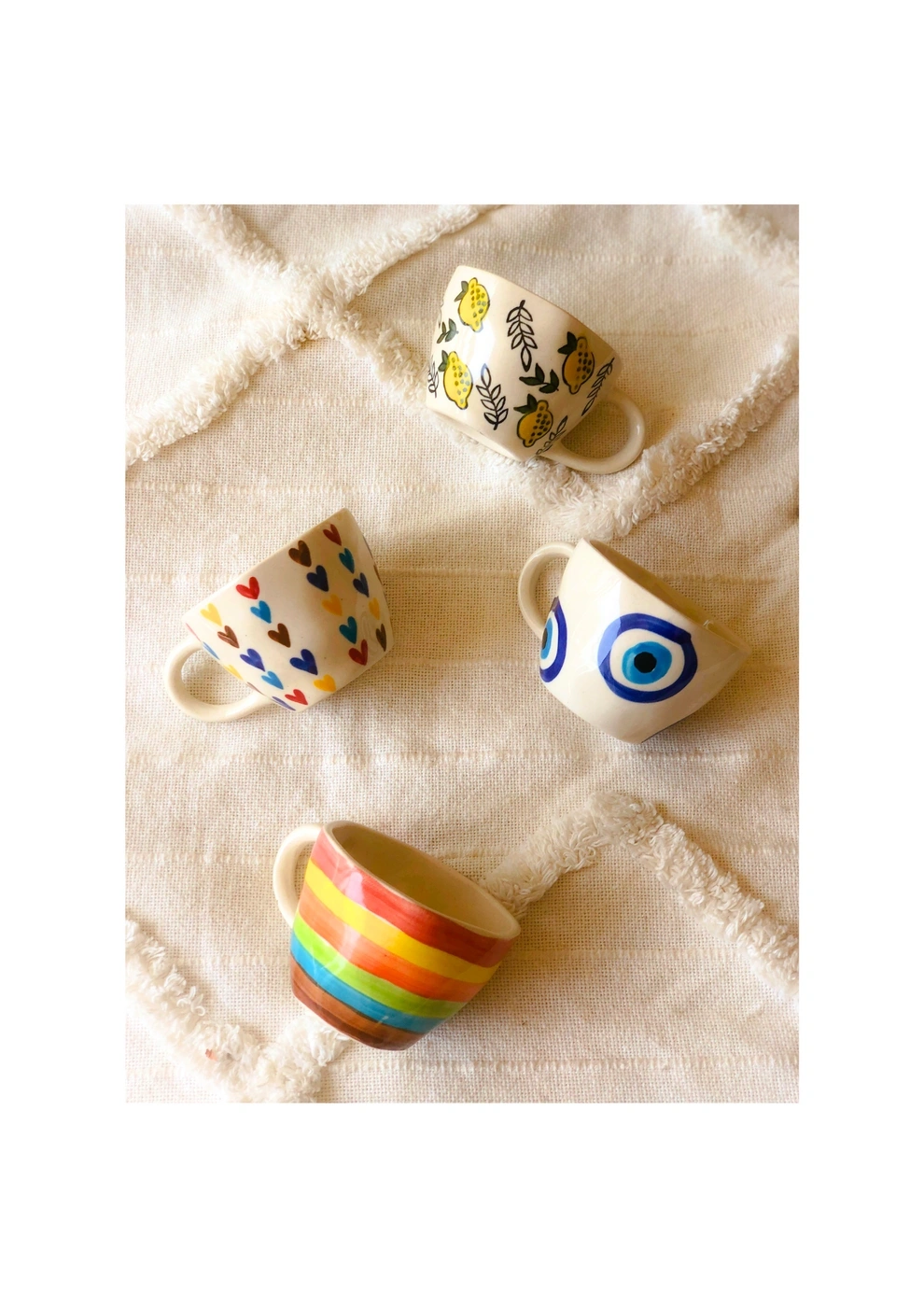 A colorful striped Easter egg rests on a textured cloth with a beige backdrop.