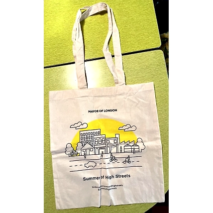 A canvas tote bag featuring a line drawing of a cityscape, with